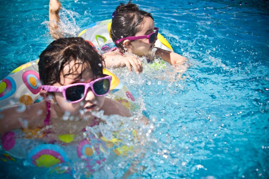 Kinder mit Schwimmhilfe beim Planschen im Becken