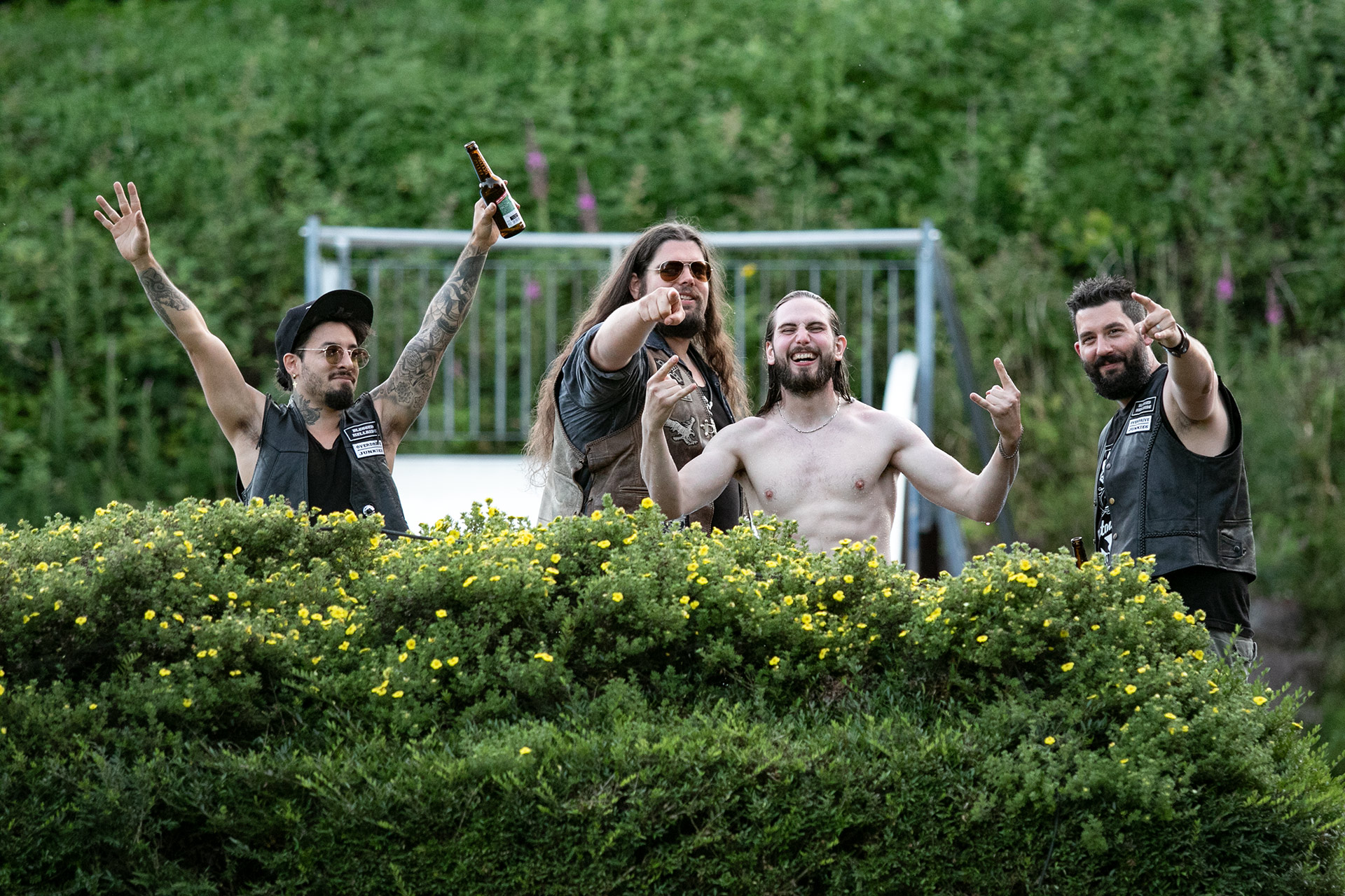 Schwimmen erlaubt! Einige Rockfans am Beckenrand, die dem Fotografen zuprosten.